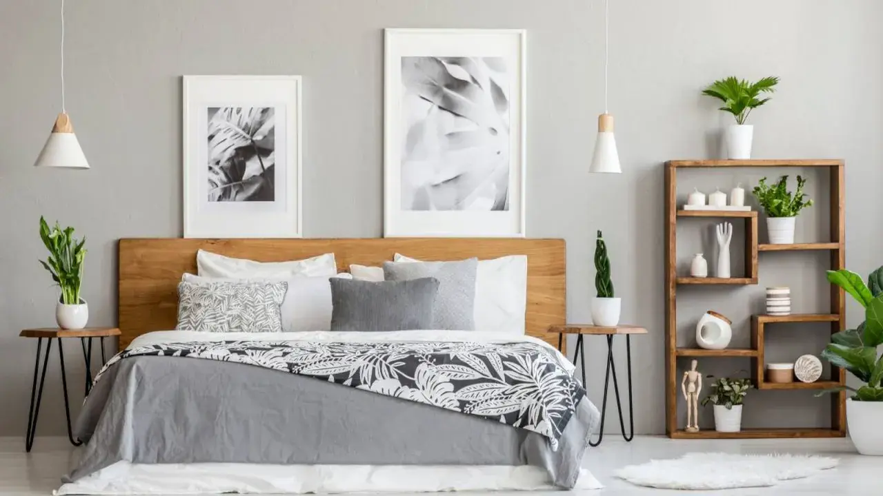 Dormitorio moderno con cama de madera, cuadros botánicos y estantería. Los tonos grises para paredes interiores crean un ambiente sereno y elegante.