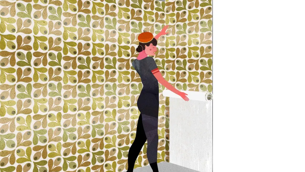 Mujer con boina naranja y vestido gris, aplicando papel pintado con patrón de olivas. Aprende como rematar papel pintado para un acabado perfecto.