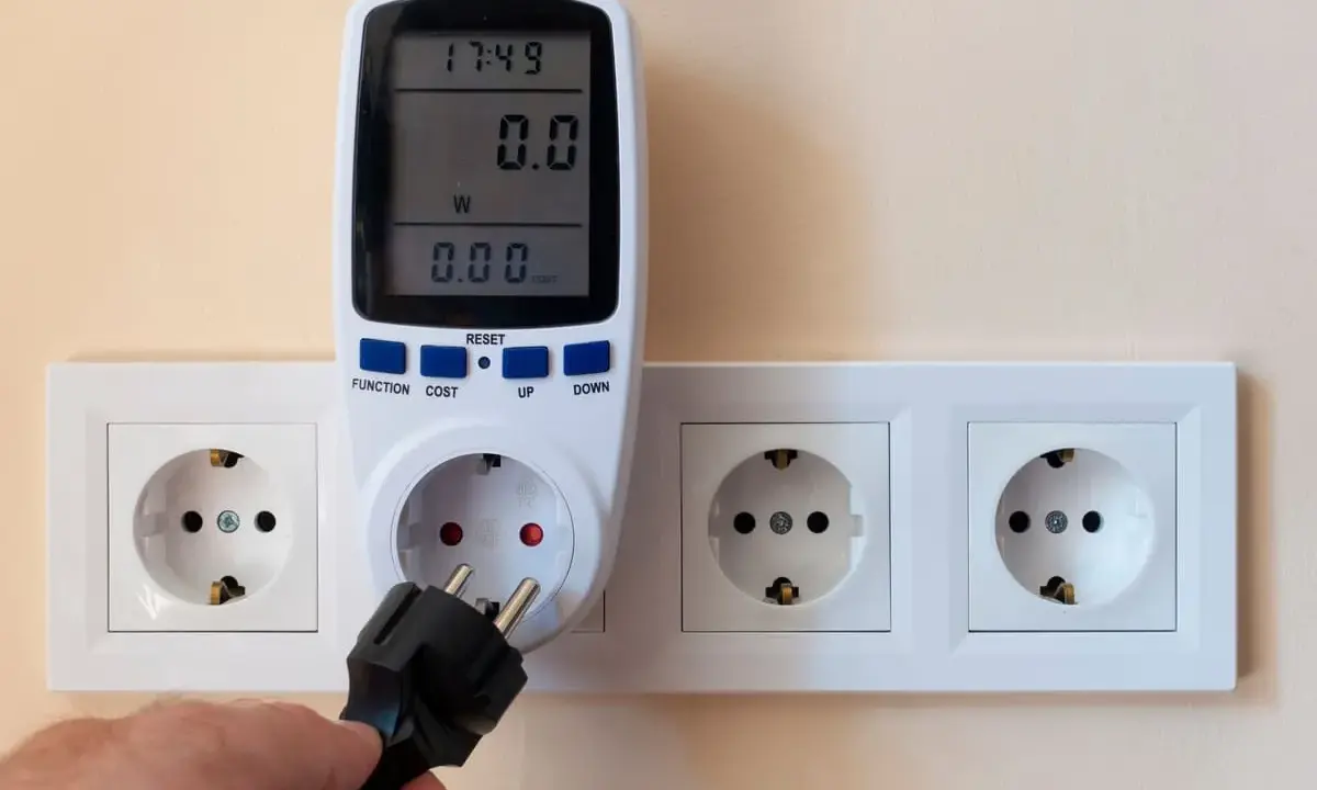 Un enchufe se conecta a un controlador de potencia eléctrica que mide el consumo.