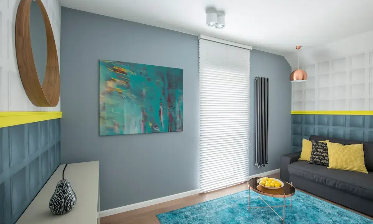Sala moderna con arte abstracto que muestra cuáles son los colores fríos, como el azul turquesa y el gris.
