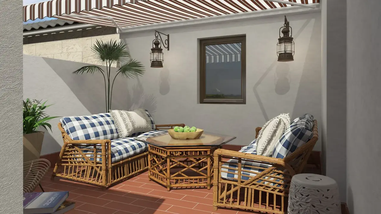 Acogedora decoracion patio interior con muebles de mimbre, cojines a cuadros y un toldo a rayas.