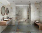 Baño moderno con paredes y suelo de baldosas grises y oxidadas. Los tonos tierra y dorados de las baldosas muestran que colores combinan con el gris en un baño.
