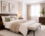 Habitación serena con cama de madera oscura, ropa de cama beige y verde salvia, y cuadros abstractos. Los colores de la habitación crean un ambiente acogedor.