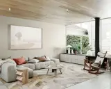 Salón moderno con sofá modular gris, alfombra abstracta y arte de playa. Muestra todos los estilos de decoración de interiores.