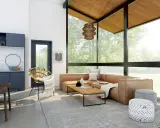 Sofá de cuero marrón, mesa de centro de madera, alfombra gris, silla de mimbre y pufs decorados con patrones, ejemplos de **ruido visual** en un salón moderno.