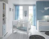 Habitación de bebé con cuna blanca, cómoda azul y estantería. Los colores para habitación de bebé son serenos, con predominio del azul y blanco.