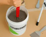 Mezclando estabilizador en un cubo para quitar gotele al temple. Herramientas de bricolaje a mano.