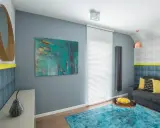 Sala moderna con arte abstracto que muestra cuáles son los colores fríos, como el azul turquesa y el gris.