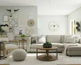 Sala de estar con sofá seccional color beige gris, mesa de centro, sillón de ratán y decoración de pared con calavera de toro.
