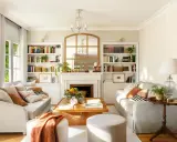 Un salón acogedor con sofás blancos y madera, sobre un fondo de color de pared para muebles blancos y madera.