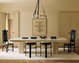 Comedor elegante con mesa blanca, sillas negras y una paleta de colores crema. Arte abstracto y cortinas suaves complementan el espacio.