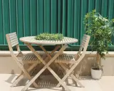 Conjunto de madera para dos personas en unas terrazas pequeñas con encanto. Una planta verde decora el rincón.