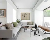 Salón moderno con sofás grises, mesas bajas y acceso directo a una terraza, creando un espacio fluido para unir terraza y salón.