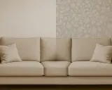 Sofá beige frente a pared dividida: una mitad con gotelé y la otra con papel pintado floral.