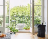 Balcones con plantas verdes y luces decorativas, invitando a disfrutar del exterior desde un acogedor interior.