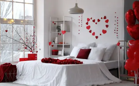 Un dormitorio decorado con un estilo romántico, lleno de corazones rojos y globos, ideal para San Valentín.