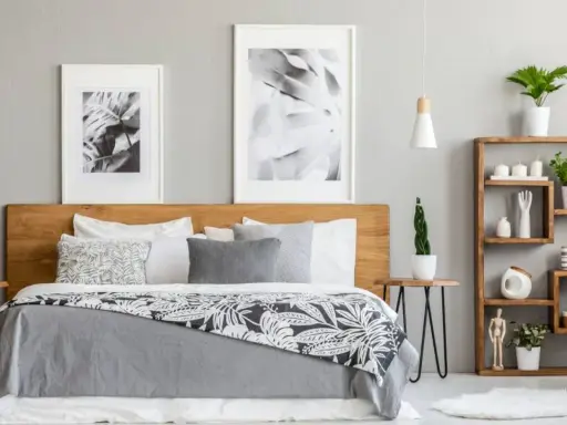 Dormitorio moderno con cama de madera, cuadros botánicos y estantería. Los tonos grises para paredes interiores crean un ambiente sereno y elegante.
