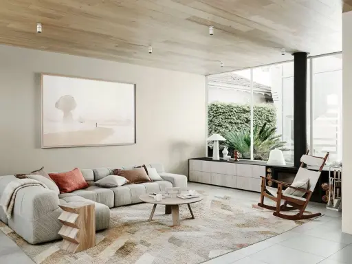 Salón moderno con sofá modular gris, alfombra abstracta y arte de playa. Muestra todos los estilos de decoración de interiores.