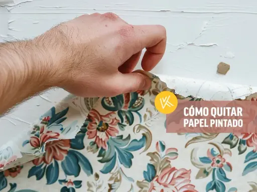Mano retirando papel pintado floral de una pared blanca. Aprende cómo quitar papel pintado sin dañar la pared.