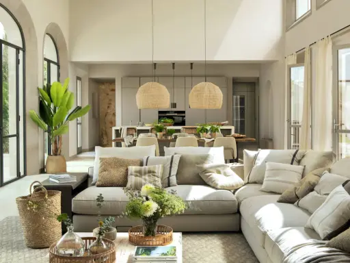 Salón y cocina integrados con **estilo moderno decoración**. Sofá modular beige, cestas de mimbre, plantas y lámparas de fibras naturales.