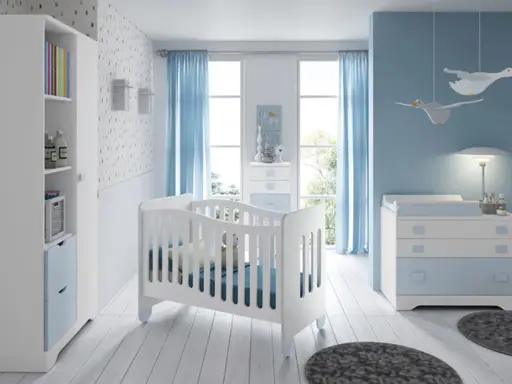Habitación de bebé con cuna blanca, cómoda azul y estantería. Los colores para habitación de bebé son serenos, con predominio del azul y blanco.