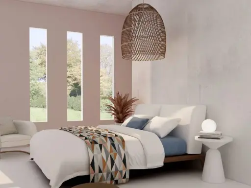 Acogedora habitación blanca y beige con cama confortable, sillón y vistas al jardín a través de ventanas verticales.