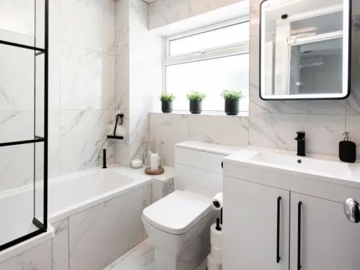 Elegantes azulejos de mármol blanco y negro para un baño pequeño. Ideas para un baño moderno y funcional.