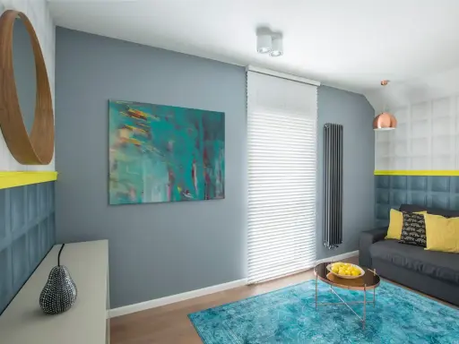 Sala moderna con arte abstracto que muestra cuáles son los colores fríos, como el azul turquesa y el gris.
