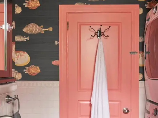 Un baño con papel tapiz de peces y **puertas de dos colores**: una rosa coral y otra de madera oscura con espejo.