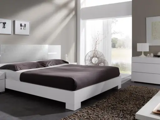 Habitación con muebles blancos y color pared neutro. Cama moderna, mesitas de noche, cómoda y espejo.