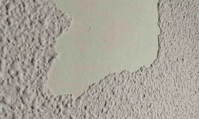 Detalle de pared con gotelé descascarillado, mostrando la capa inferior lisa. Ideal para aprender como quitar gotele.