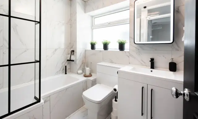Elegantes azulejos de mármol blanco y negro para un baño pequeño. Ideas para un baño moderno y funcional.