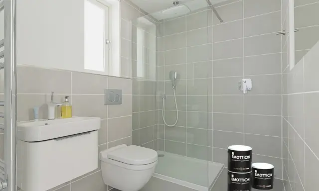 Moderno baño con ducha y lavabo. Latas de pintura para azulejos, perfectas para tus ideas para pintar azulejos baño.