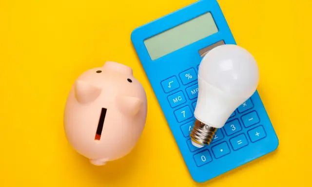 Hucha rosa, calculadora azul y bombilla LED. Ideas para como ahorrar en la factura del gas y la luz.