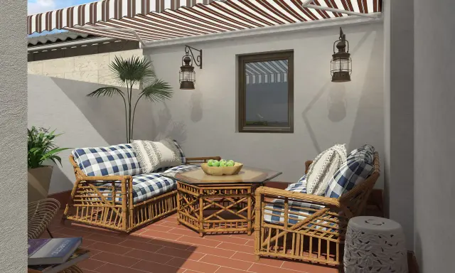 Acogedora decoracion patio interior con muebles de mimbre, cojines a cuadros y un toldo a rayas.