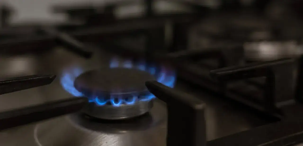 La llama azul de un quemador de gas en una cocina, simbolizando el momento de dar de alta el gas por primera vez.