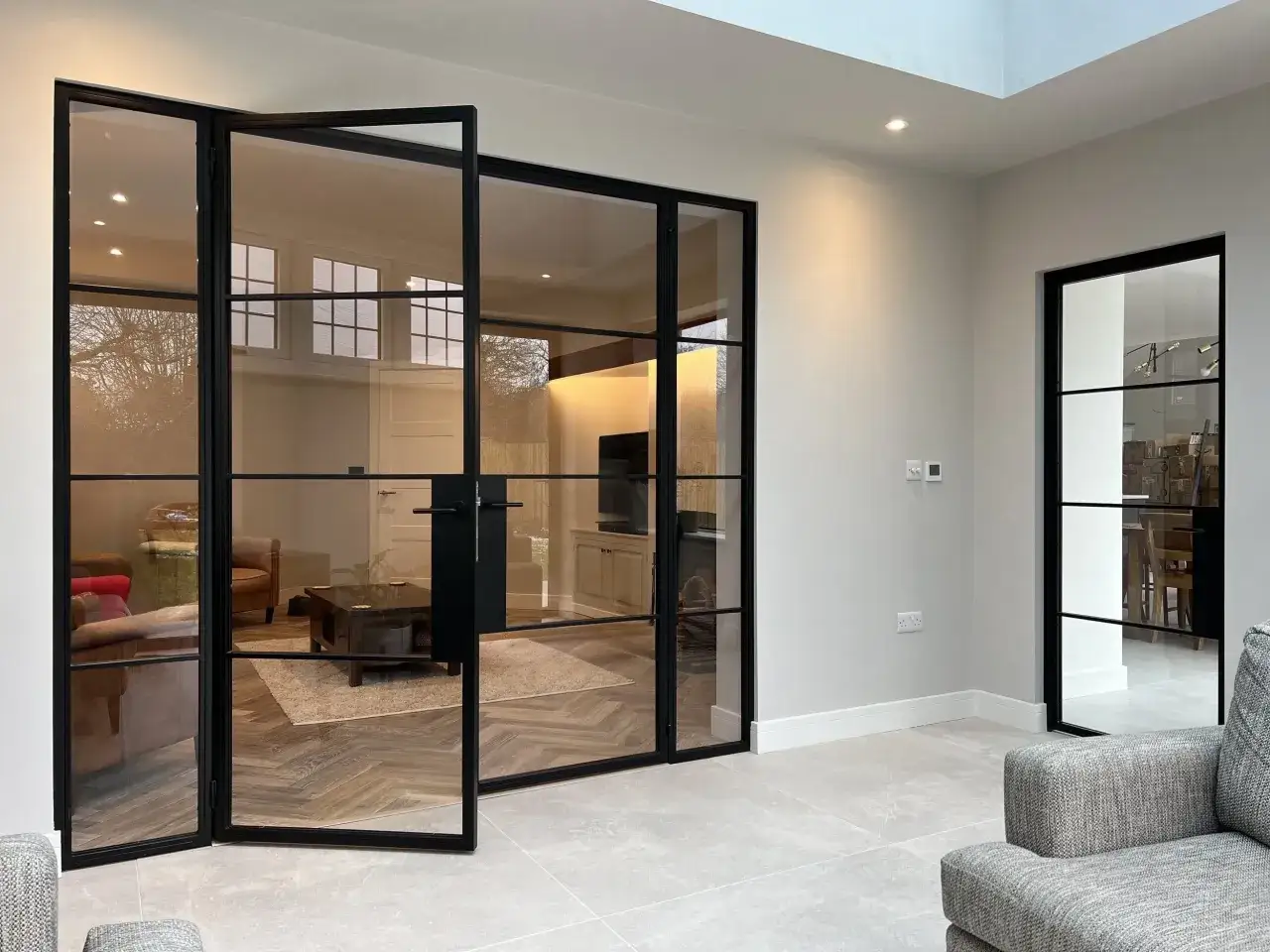 Puertas de interior negras con paneles de vidrio, un ejemplo de c&oacute;mo elegir el color de las puertas de interior para un estilo moderno.