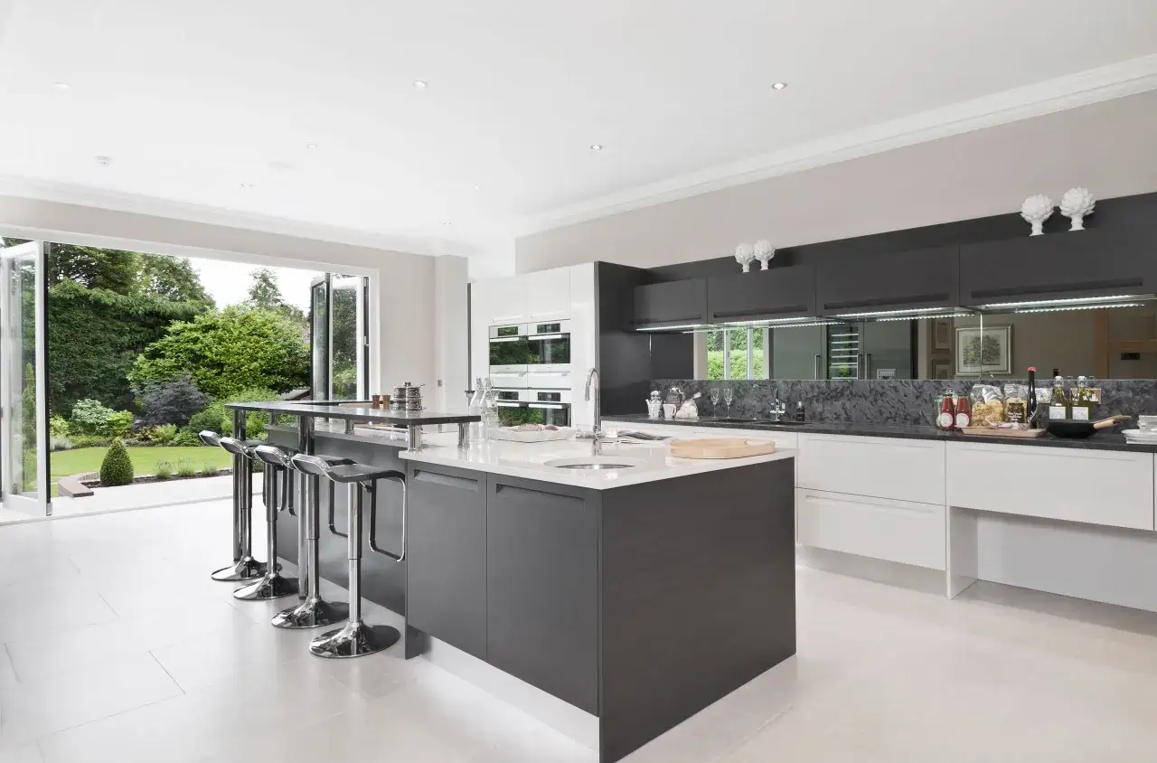Cocina moderna con isla central y acceso directo a una terraza ajardinada, ideal para ampliar cocina con terraza y disfrutar del exterior.