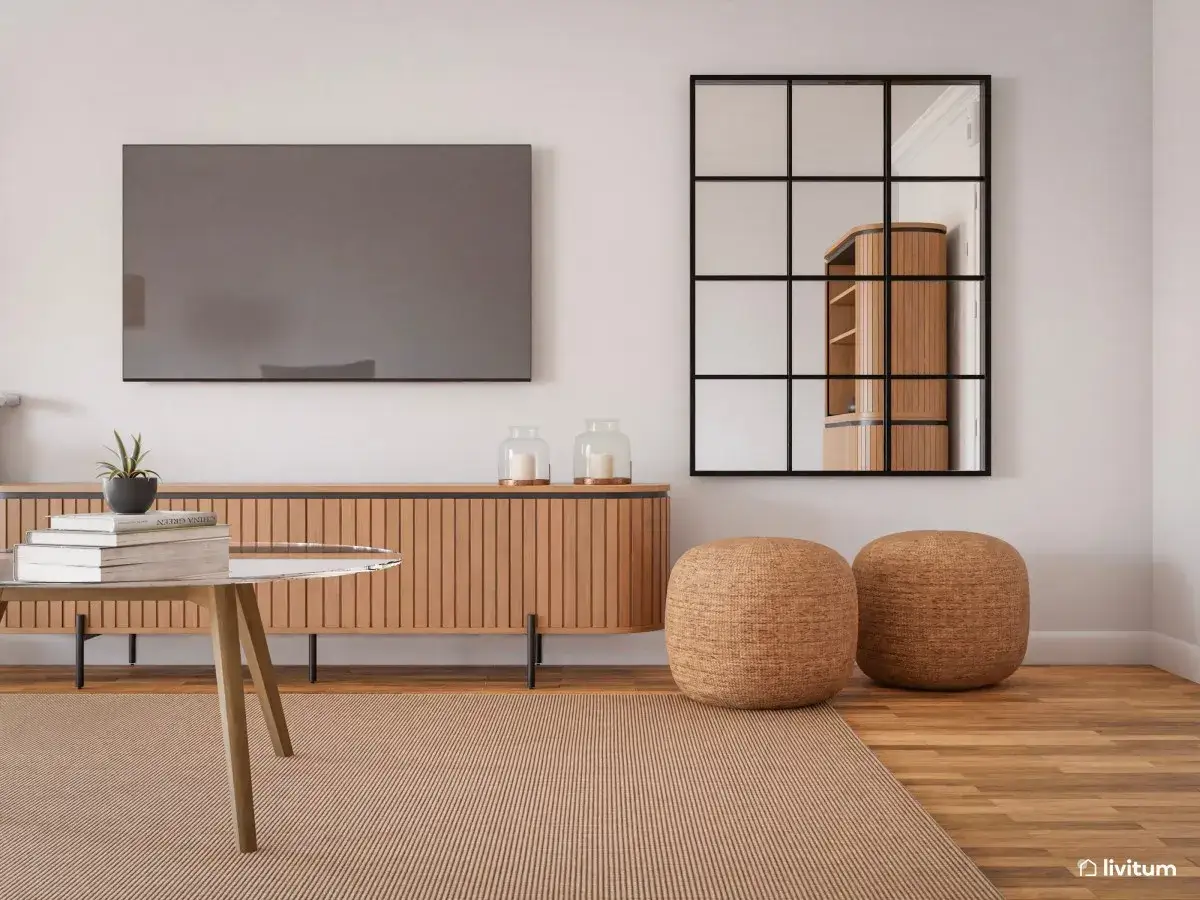 Sala de estar con mueble de madera, espejo industrial y dos pufs redondos. Un toque de color lila en la planta aporta vida.