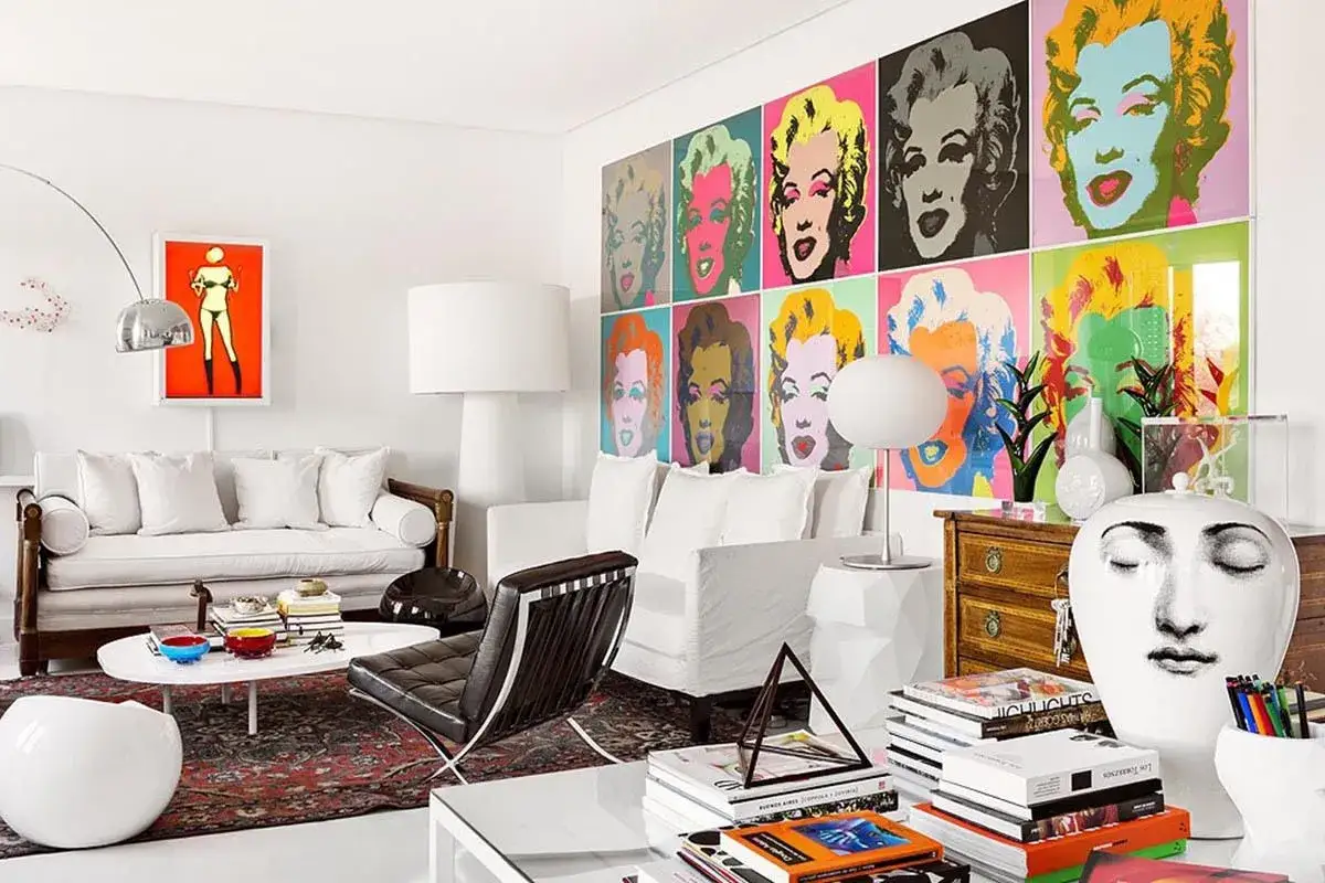 Sala de estar con arte pop de Marilyn Monroe, muebles blancos y un sillón de cuero negro. Un espacio con estilo vanguardista.