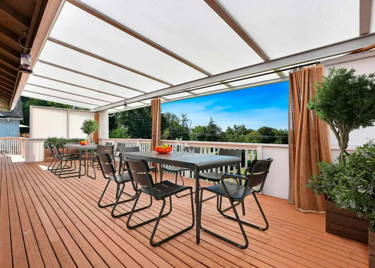 Terraza cubierta con techo de policarbonato, ideal para saber como cubrir una terraza con poco dinero. Mesas y sillas negras, vista al bosque.