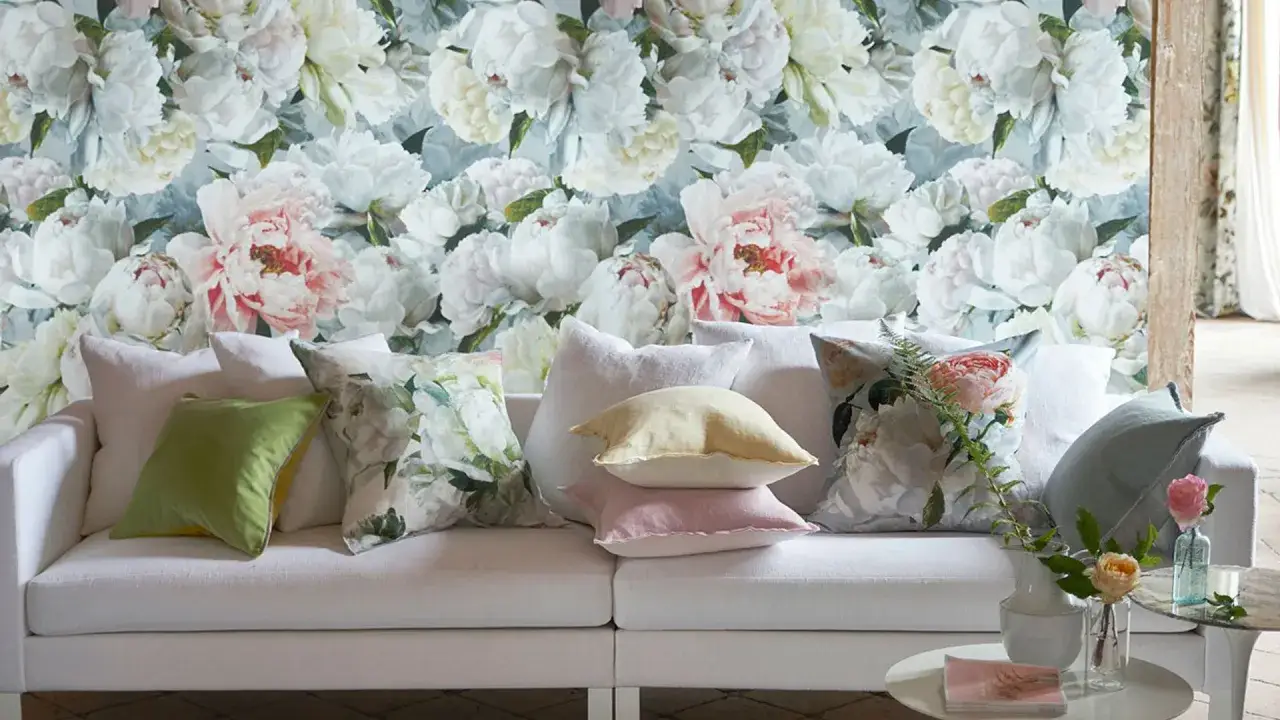 Sofá blanco con cojines que presentan hermosos estampados florales, evocando un jardín de ensueño.