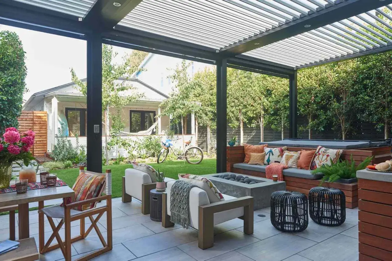 Terraza moderna con asientos, chimenea y jacuzzi. El techo de lamas permite hacer sombra y disfrutar del exterior.