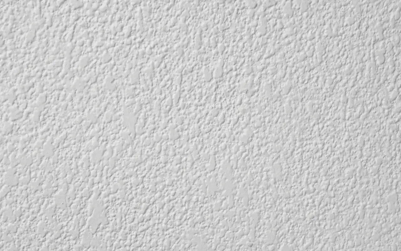 Textura de pared con gotele grueso, creando un relieve irregular y r&uacute;stico.