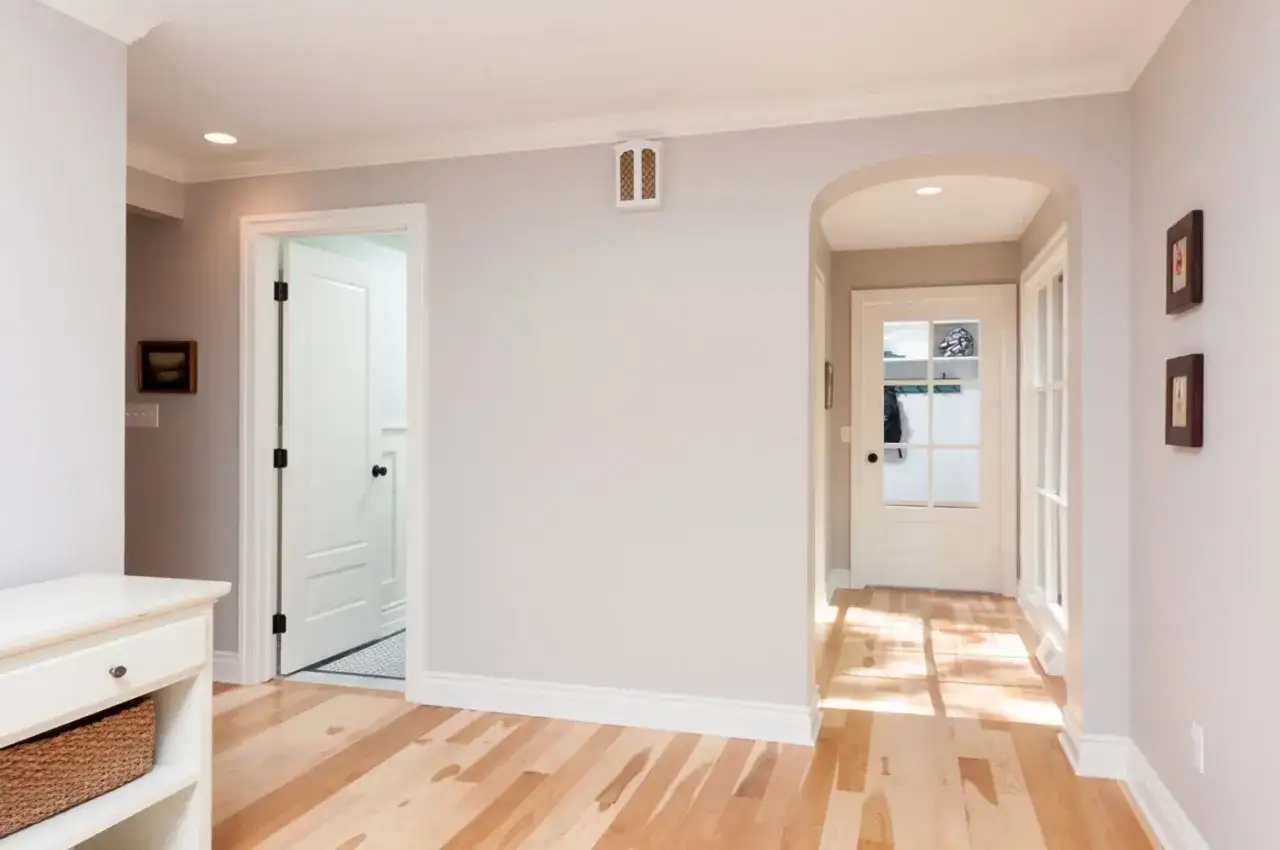 Pasillo con puertas y ventanas, destacando los distintos tipos de molduras de madera en techos y zócalos.